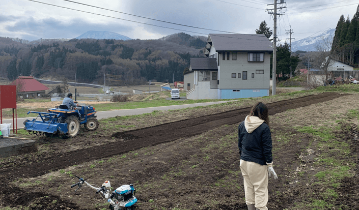 飯田さんの奥さんが、庭で畑仕事をしている